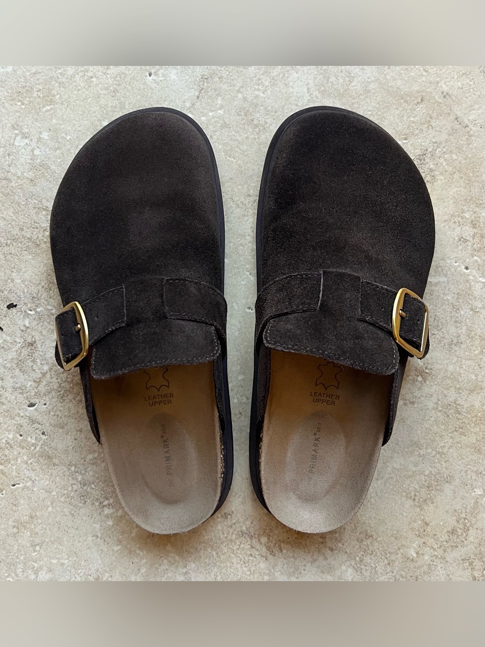 Slip-on clogs with a leather upper and rubber sole.